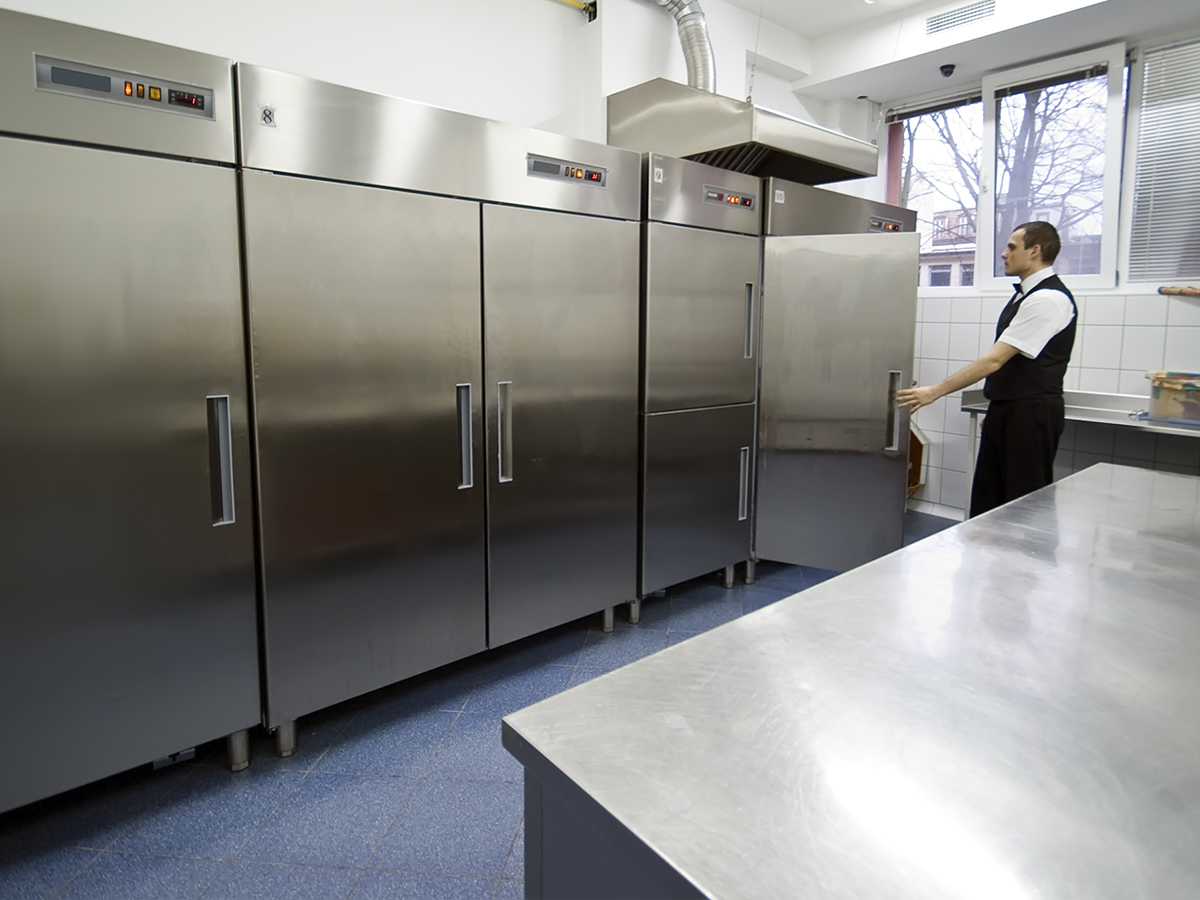 A waiter looking in a commercial kitchen.