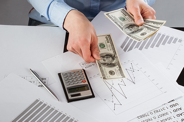 Man reviewing graphs and charts on sheets of paper.