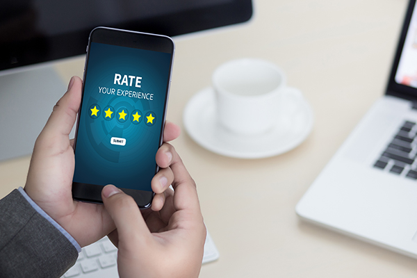 Man holding phone, and on the screen says “Rate Your Experience.”