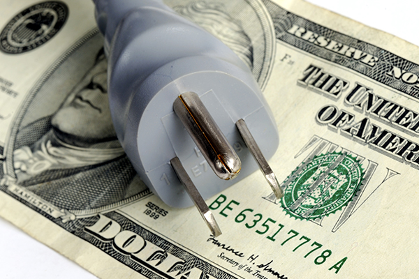 Plug-in laying across a stack of 100 dollar bills.