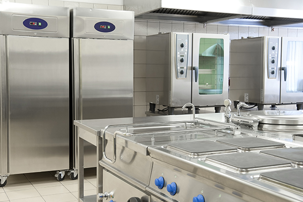 Empty restaurant kitchen with professional equipment made of metal.
