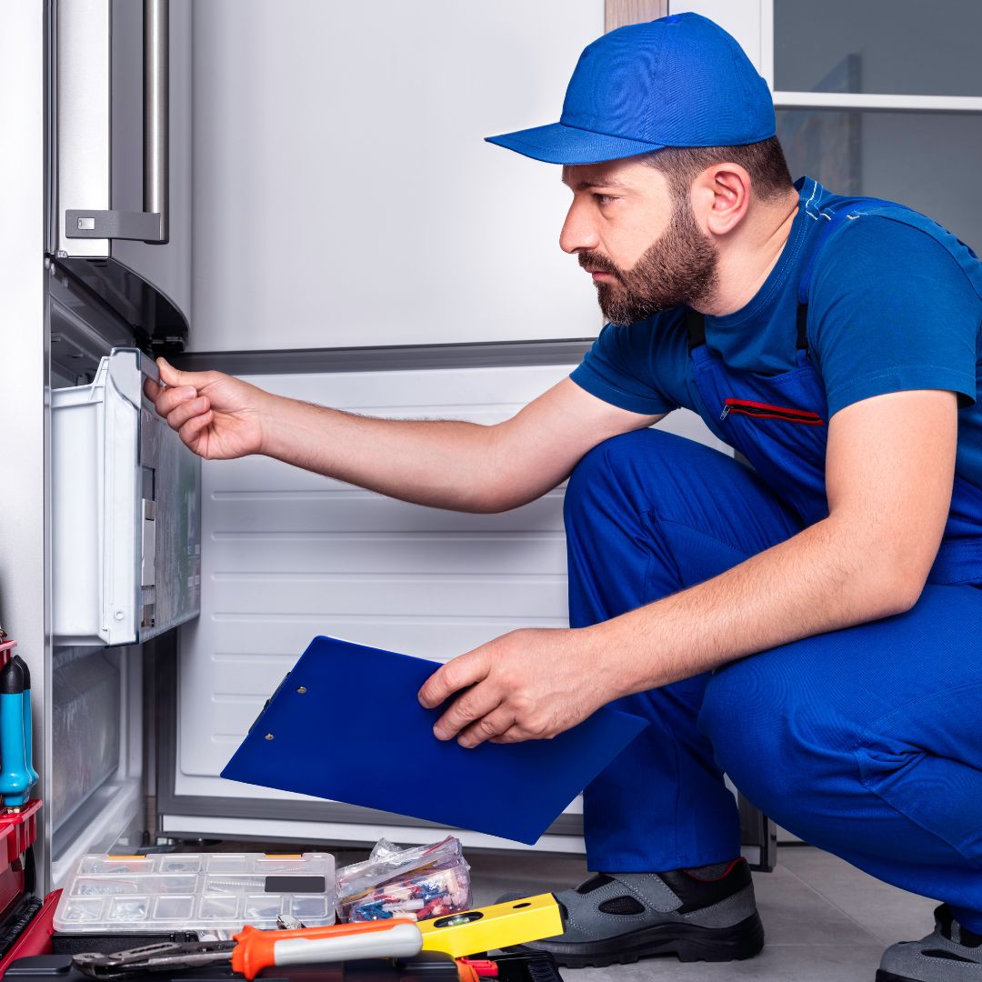 Repair man inspecting refrigerator