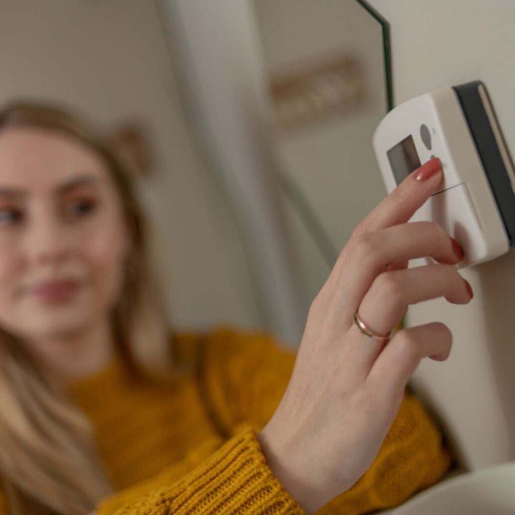 Woman messing with her thermostat
