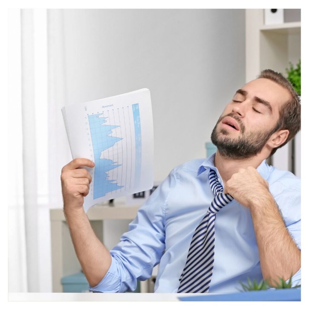A man giving himself some air with a paper