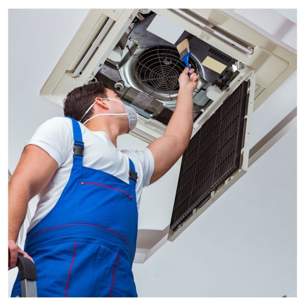 Man cleaning an AC vent