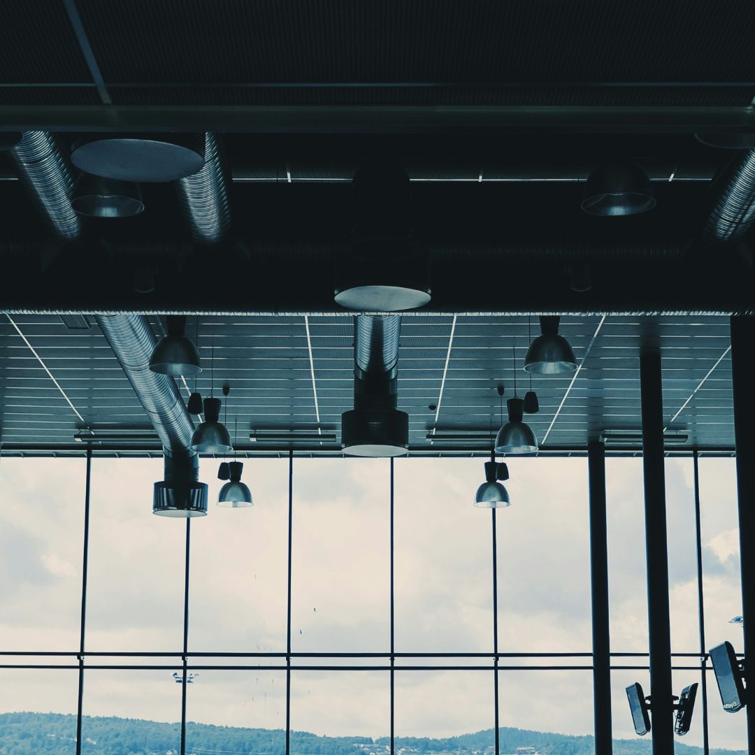 ductwork in dark office, wall of windows