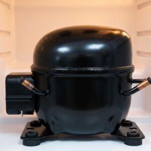 A close-up view of a humming commercial refrigerator compressor.
